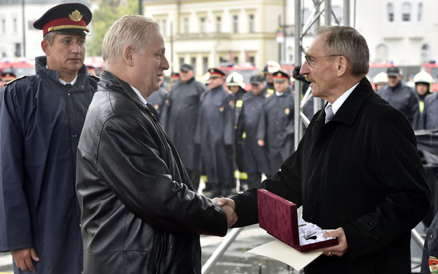 Pintér Sándor belügyminiszter (j) jelképesen átadja az új tűzoltóautók kulcsait Tarlós István főpolgármesternek, a háttérben Varga Ferenc tűzoltó dandártábornok, a Fővárosi Katasztrófavédelmi Igazgatóság vezetője az új tűzoltóautók átadóünnepségén