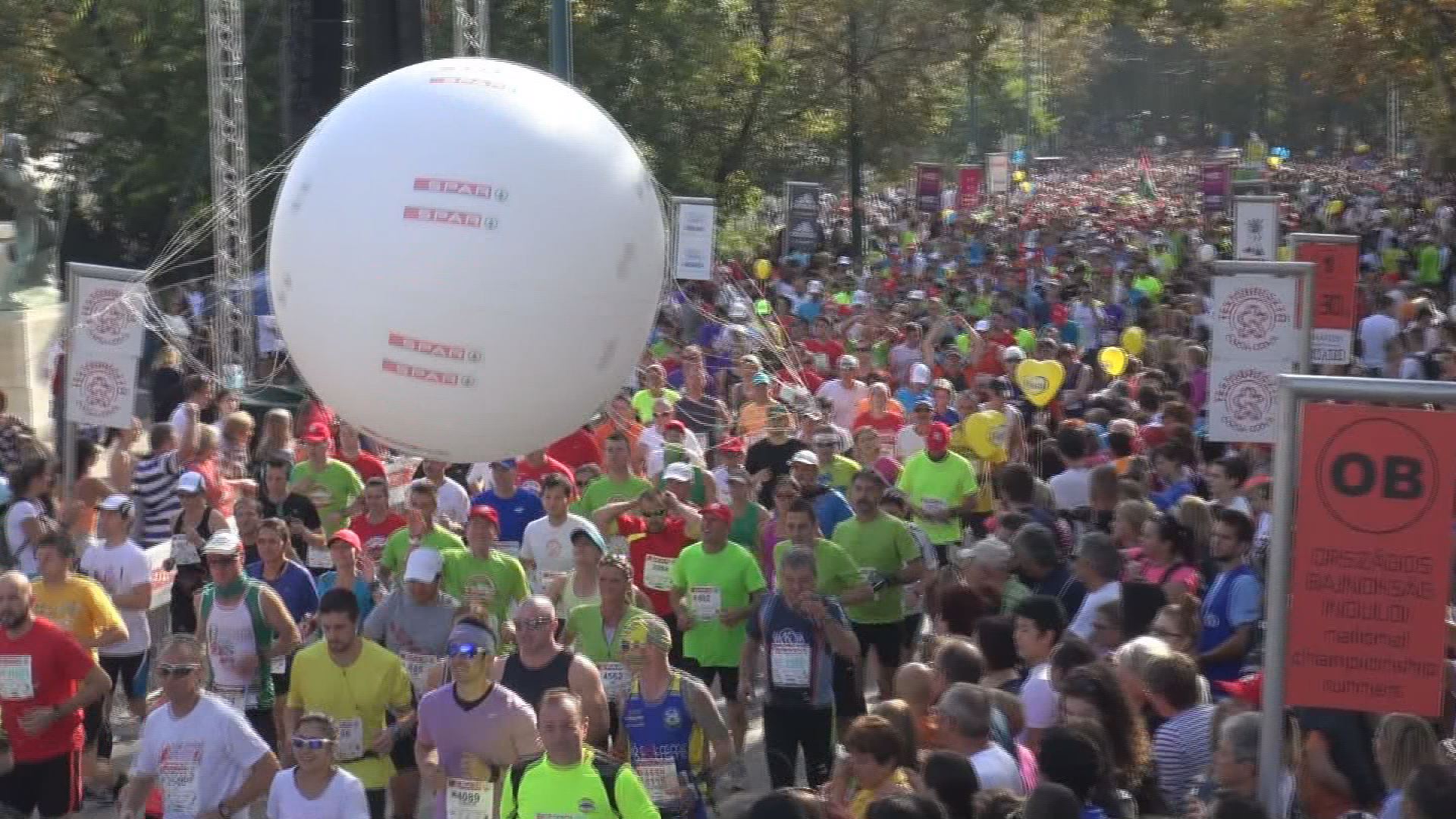 Futó emberek színes kavalkádja, ahogy elindul a verseny mezőnye. Ha a képre kattint, a videó oldalára jut.