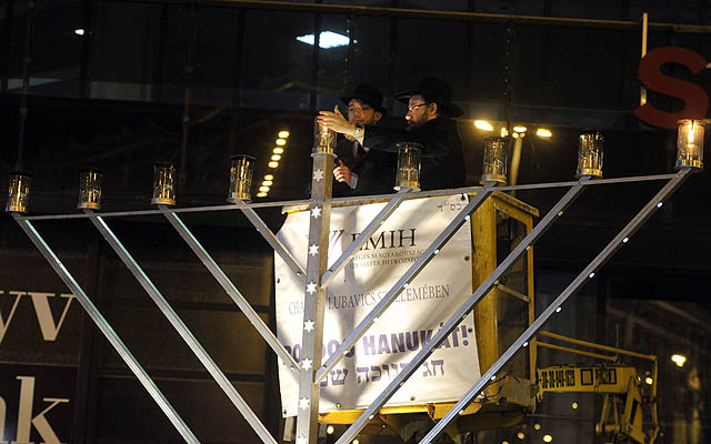 Deputy Mayor (L) Balázs Szeneczey and Báruch Oberlander, Head of the Ortodox Rabbinate of Budapest and the Chabad-Lubavitch movement, lighting the servant candle at Nyugati square on the eve of Hanukah, the eight day long Jewish religious holiday.