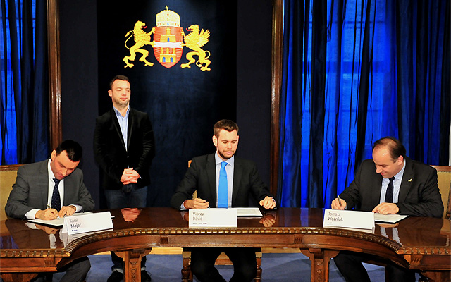 Karel Majer, a Skoda igazgatósági tagja (b1), Vitézy Dávid, a BKK vezérigazgatója (középen) és Tomasz Woźniak, a Solaris kereskedelmi vezetője (j1) aláírják a trolibuszszerződést dr. Szeneczey Balázs (b2) főpolgármester-helyettes jelenlétében