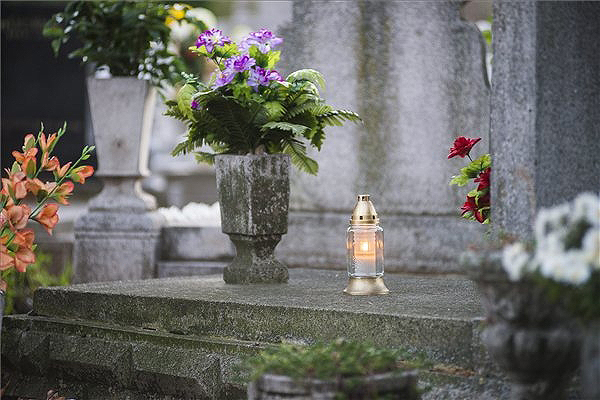 Mécses egy budapesti temetőben lévő sírkövön halottak napja alkalmából